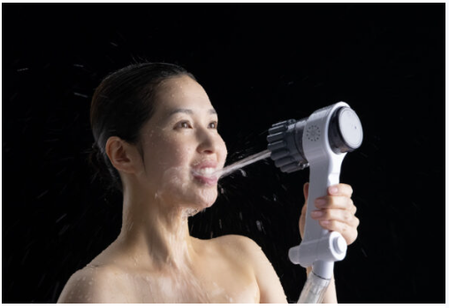 女性がシャワーで口に水を当てている画像
