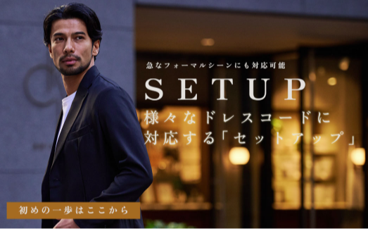 ネイビーのスーツを着た髭を生やした男性がこちらを見ている