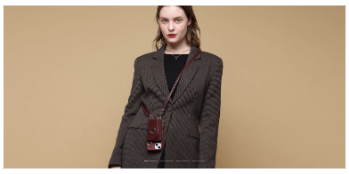 スマホケースを肩から斜め掛けをしているスーツを着た女性