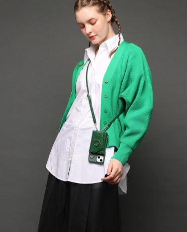 スマホケースを肩から斜め掛けしている緑色のカーデガンを着た女性