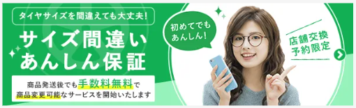 メガねをかけた女性がスマホをもって人差し指を立てている