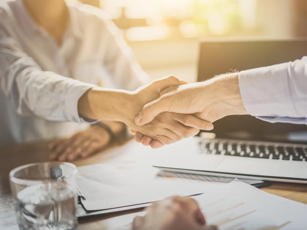 テーブルの上で握手をしている